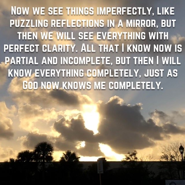 Sunlight bursting through clouds over palms, with the words of 1 Corinthians 13:12
