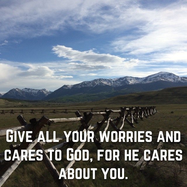 A buck-and-rail fence below snowy peaks, with the words of 1 Peter 5:7