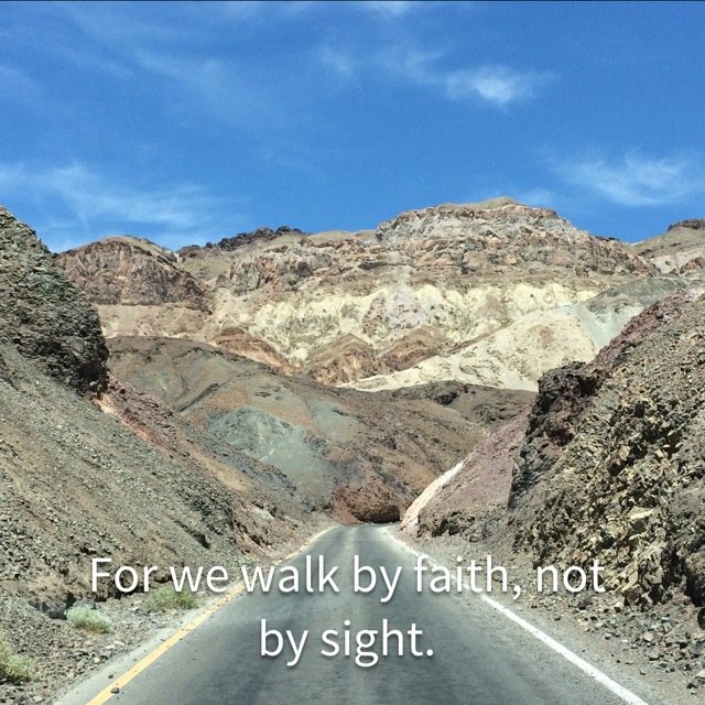A road winding into colorful desert hills, with the words of 2 Corinthians 5:7