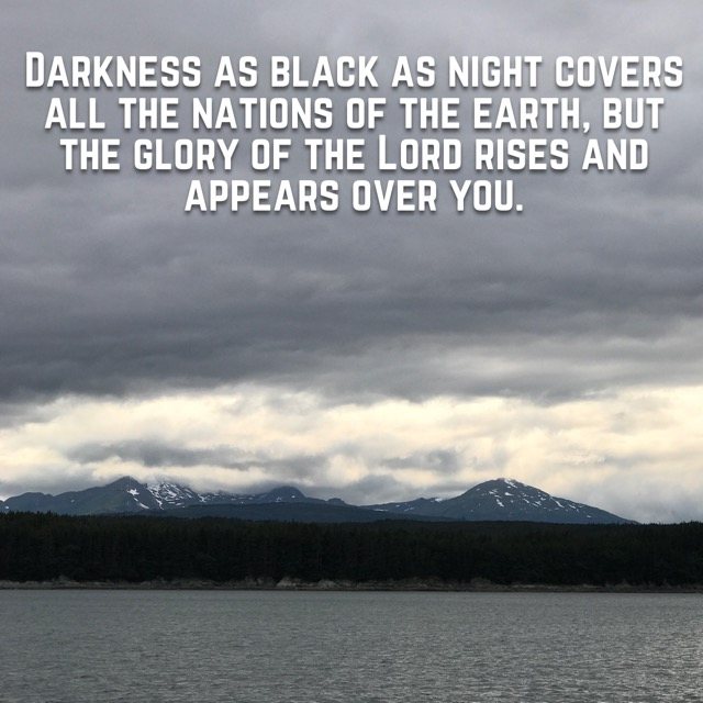 Dark clouds over mountains across the water, with the words of Isaiah 60:2