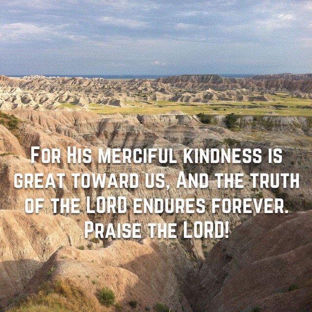 Eroded badlands under a soft sky, with the words of Psalm 117:2