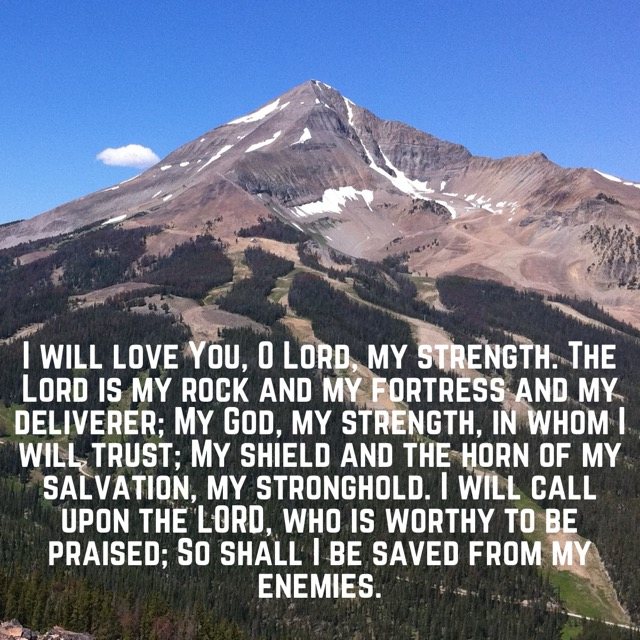 A rocky mountain peak under clear blue sky, with the words of Psalm 18:1–3