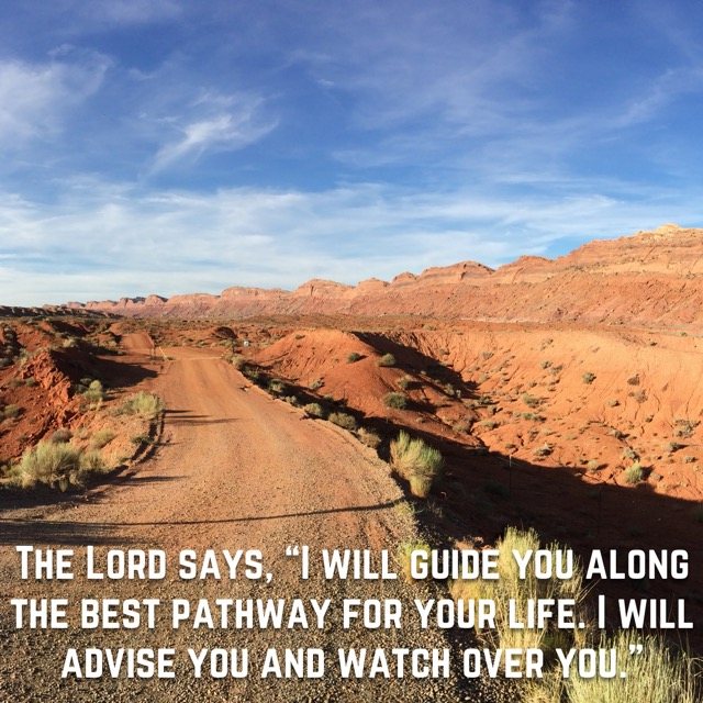 A dirt road through red desert hills, with the words of Psalm 32:8