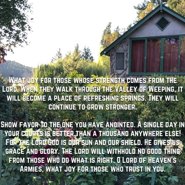 A cottage behind a summer flower garden, with the words of Psalm 84:5–12